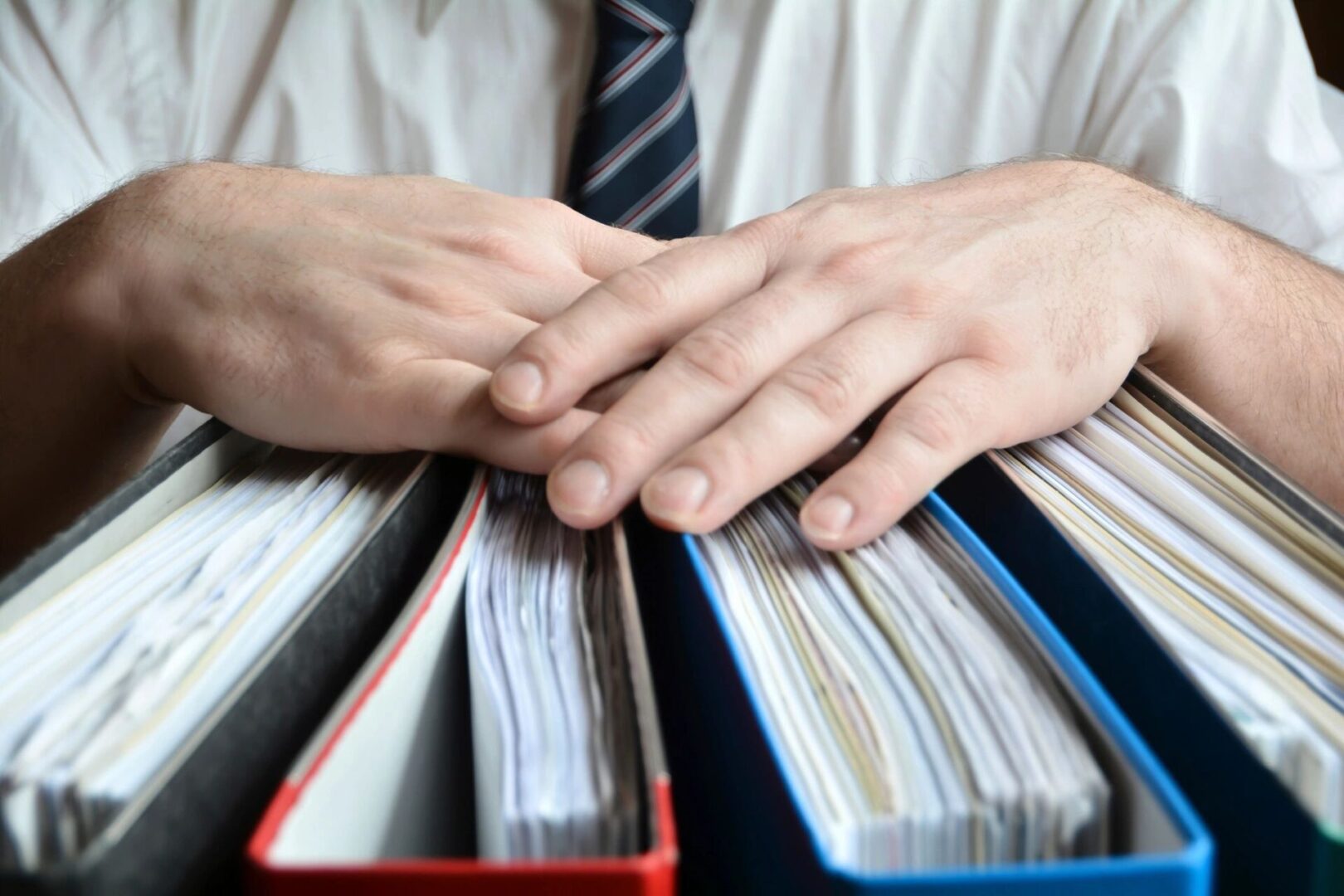 Person leaning both hands on top of file folders