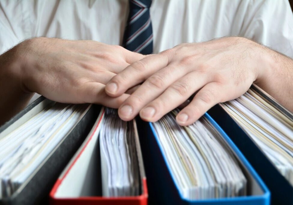 Person leaning both hands on top of file folders